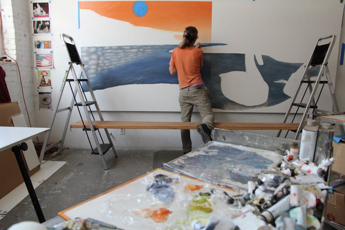 Lisa Adams in the studio painting Borderland.  Photograph by Jayme Odgers. 